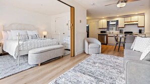 A modern bedroom with a bed, bedside tables, and a small seating area.