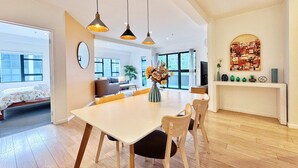 A modern living room with a dining area, large windows, and a fireplace. - Heart of Auckland 2BR Near Queen St & Skytower (Auckland)