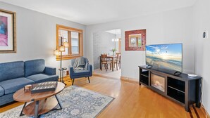 Ein modernes Wohnzimmer mit einer Couch, einem Couchtisch, einem Fernseher und einem Kamin.