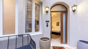 A hotel entrance with a wooden bench, a large planter, and a door marked with the number 02. - Madeleine Opera - Very nice Studio in Paris (Paris)