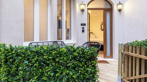 A hotel entrance with a wooden gate, a number '02' sign, and a well-maintained hedge. - Madeleine Opera - Very nice Studio in Paris (Paris)