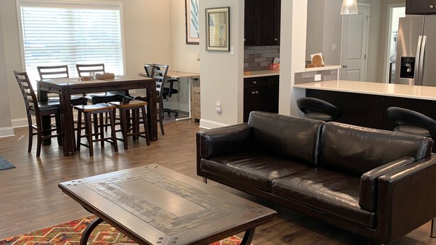 Un salon avec un canapé, une table basse et un tapis coloré.