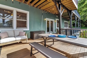 Una terrazza esterna con tavolo, panche e divano in legno.