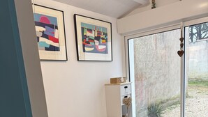 A bedroom with a bed, pillows, a dresser, and two framed artworks on the wall. - La voile blanche - A stopover with your feet in the water (Barbâtre)