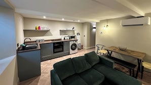 A compact living space with a kitchenette, a dining area, and a sofa.