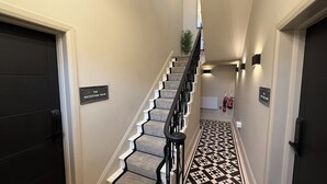 A staircase with a geometric patterned floor, a black and white color scheme, and a sign indicating 'The Mackintosh Room'. - Akroyd House - The Dean Clough Room, A brand new stunning guest house, town centre location with par (Halifax)