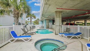 Zona de piscina exterior con sillones de descanso y jacuzzi.