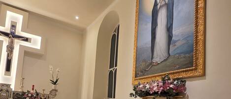 A church interior with a crucifix, altar, and a large framed painting.