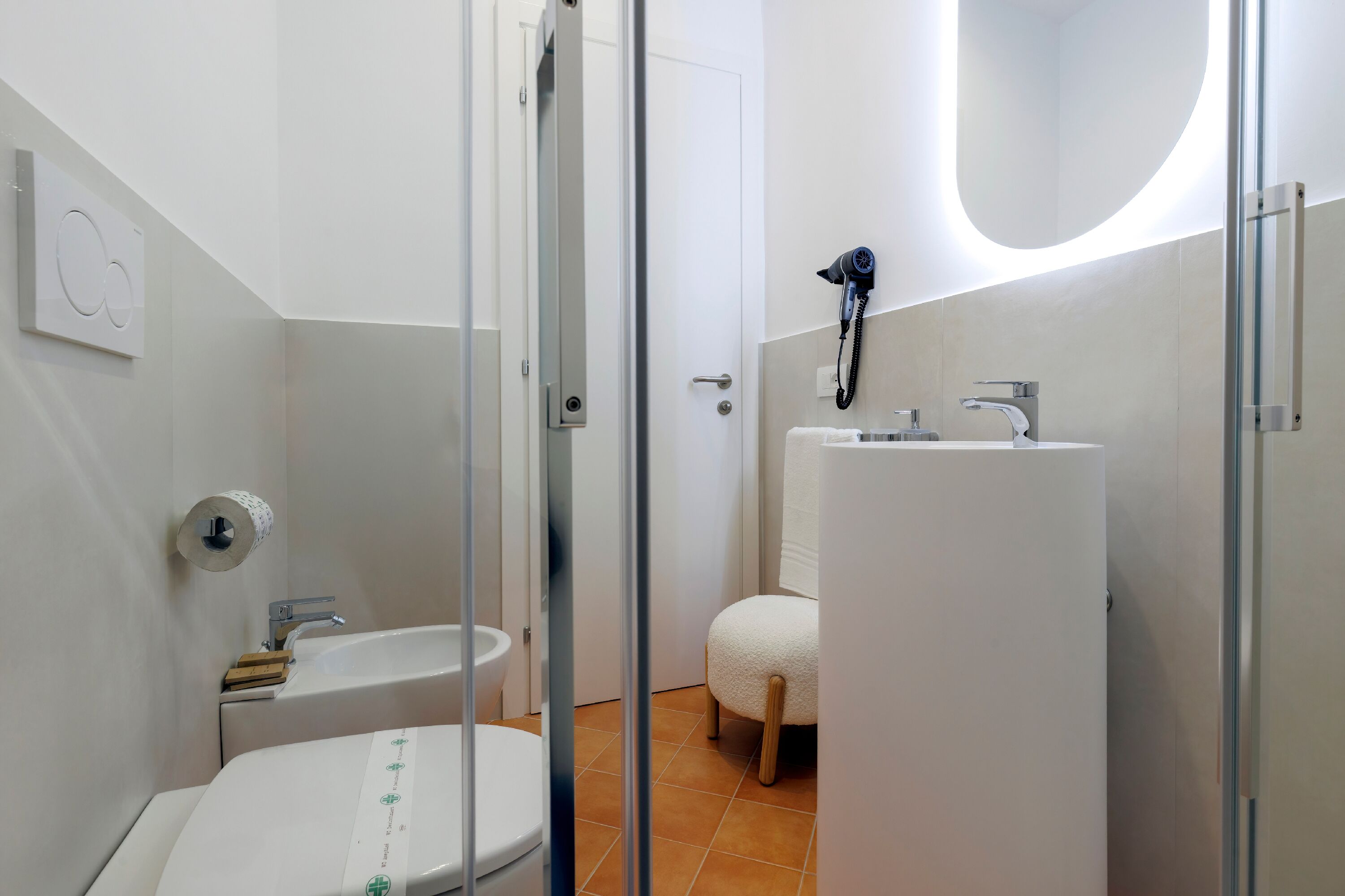 A modern bathroom with a toilet, bidet, and a large sink.
