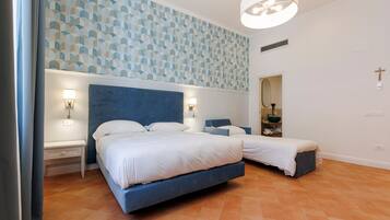Un dormitorio con una cama grande, dos mesitas de noche, una lámpara de pared y un espejo.