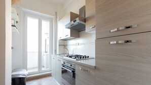 Una cocina moderna con estufa a gas, horno y alacenas de acero inoxidable.