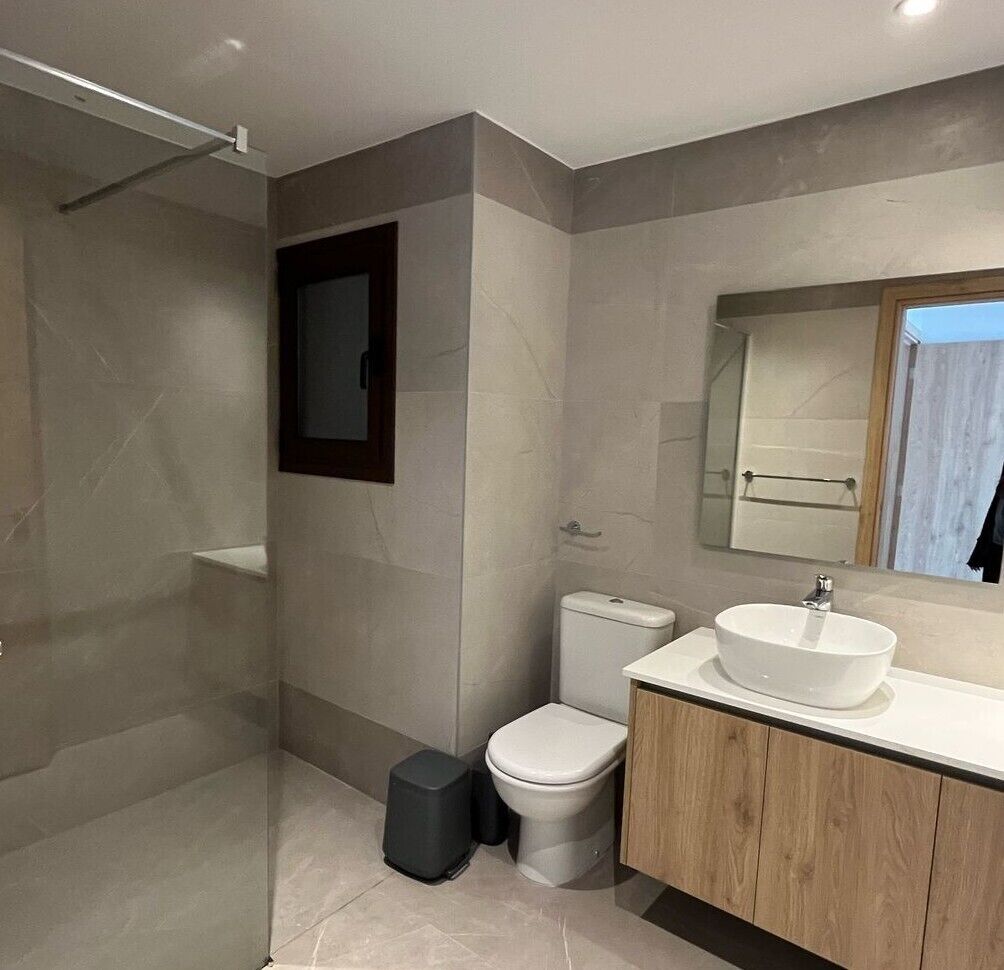 Ein modernes Badezimmer mit Dusche, Toilette und Waschtisch.