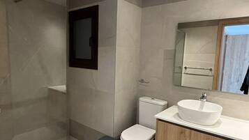 Ein modernes Badezimmer mit Dusche, Toilette und Waschtisch.