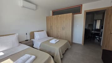 Una habitación de hotel con dos camas, un escritorio y un armario.