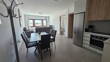Apartamento família, vista para a cidade | Área de estar | Smart TV 35 polegadas com canais digitais