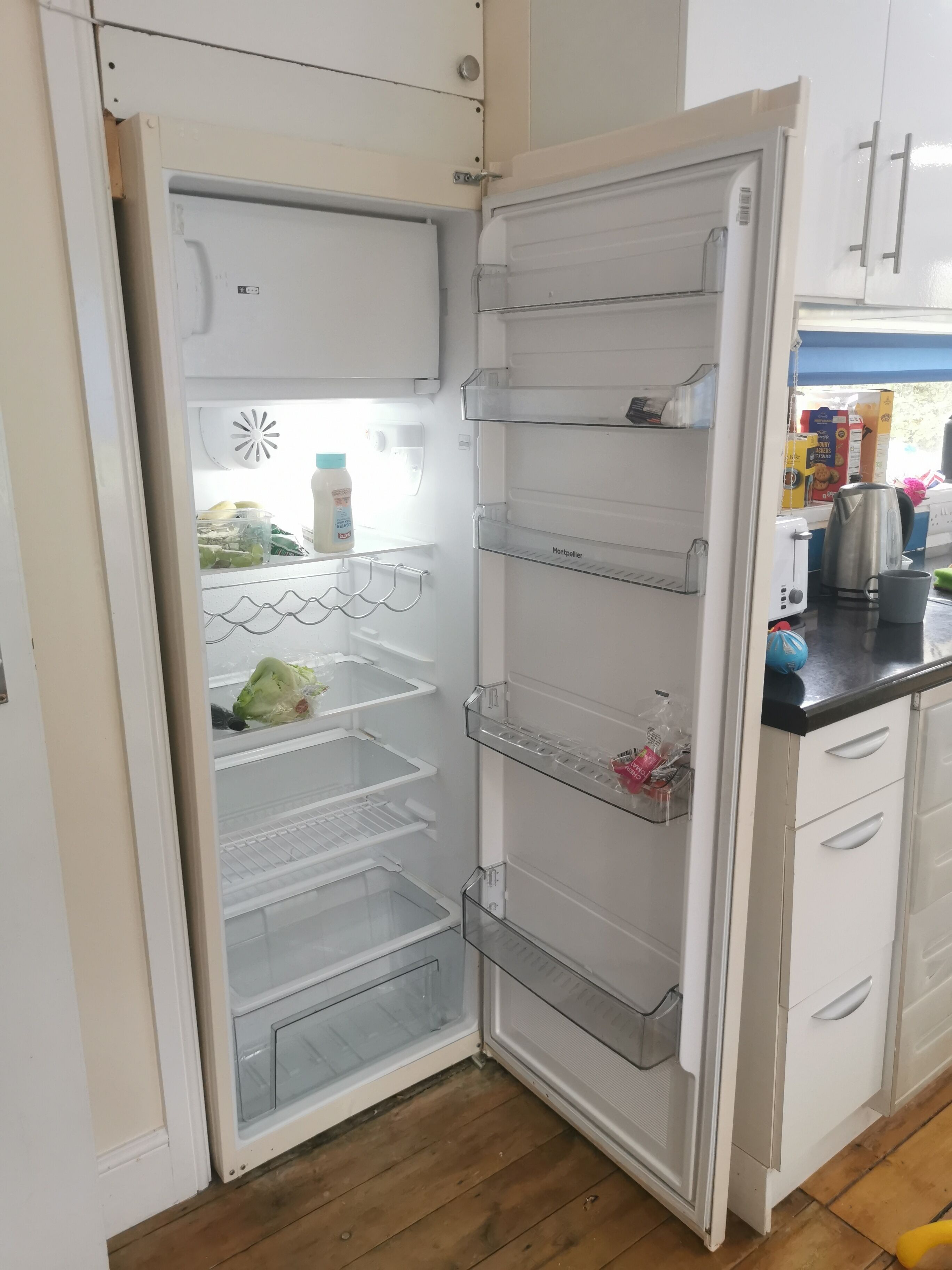 Un réfrigérateur blanc doté de plusieurs étagères et d’un compartiment congélateur.