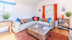 Una sala de estar acogedora con sofá, mesa de centro y estantería.