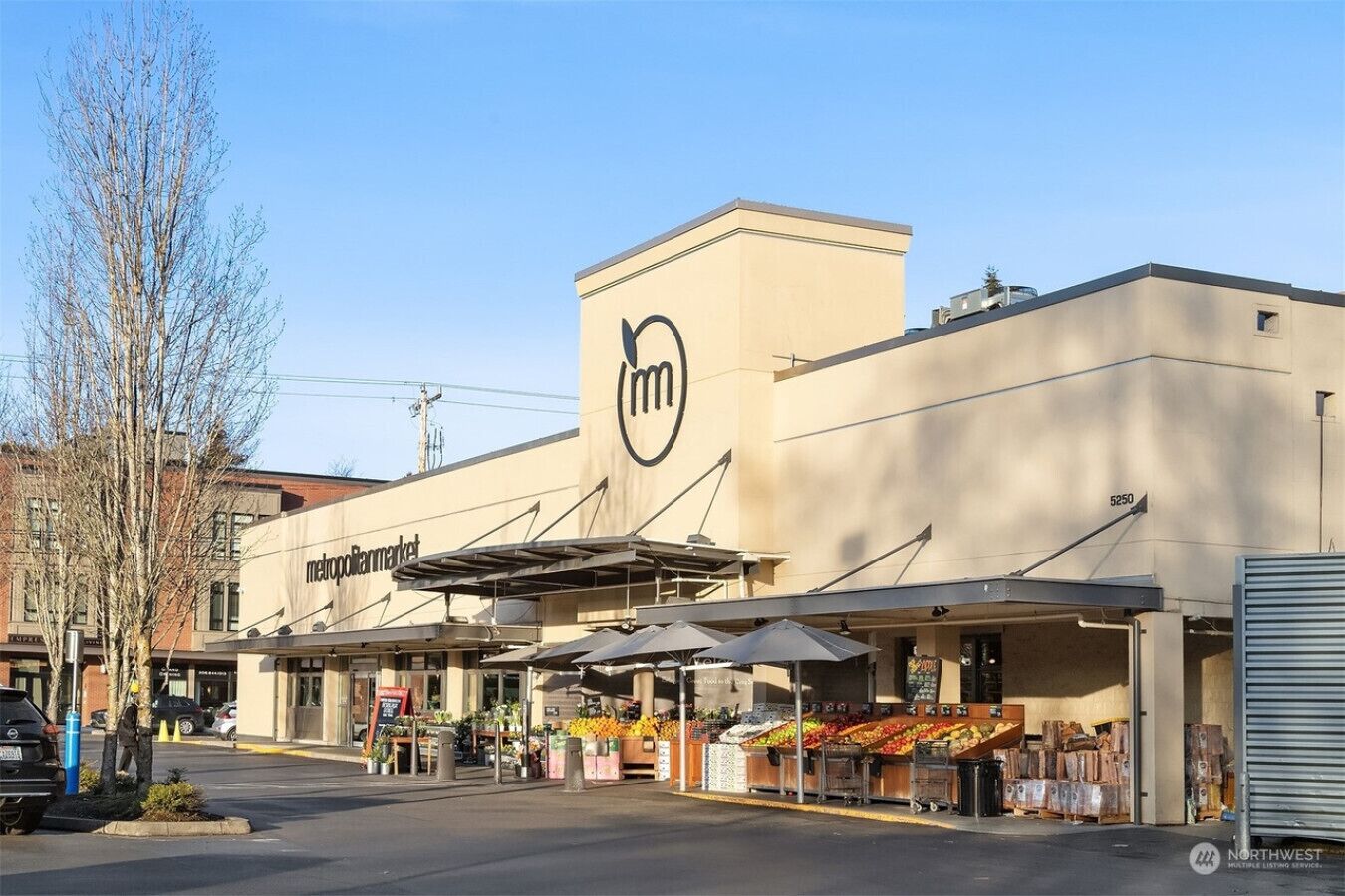 A MetroPleinMarket building with outdoor produce stands and a clear sky.
