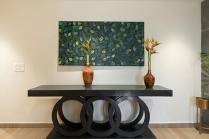 A modern reception desk with a black console and two vases with decorative flowers. - Xenious Micro  (Amritsar)