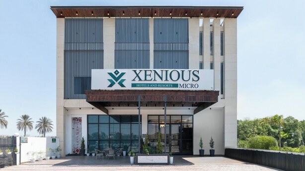A modern hotel building with a sign reading "XENIOUS HOTELS AND RESORTS MICRO". - Xenious Micro (Amritsar)