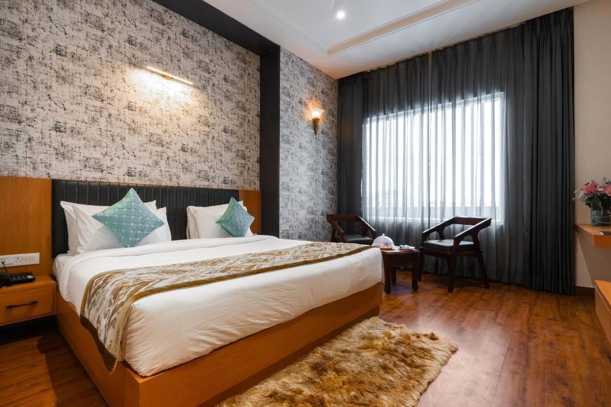 A bedroom with a large bed, a wooden headboard, a fur rug, a chair, and a nightstand.