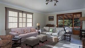 A spacious living room with a large window, two sofas, a coffee table, and a fireplace.