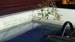 Una piscina en la azotea con vista al océano al atardecer.