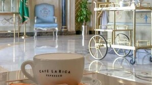 A luxurious lobby with a coffee table, a blue armchair, and a gold cart. - Alfursan Almotahida Hotel (Jeddah)