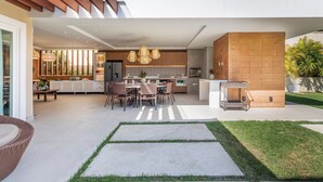 Una cocina moderna con comedor, un ventanal grande y un patio con sendero de concreto.