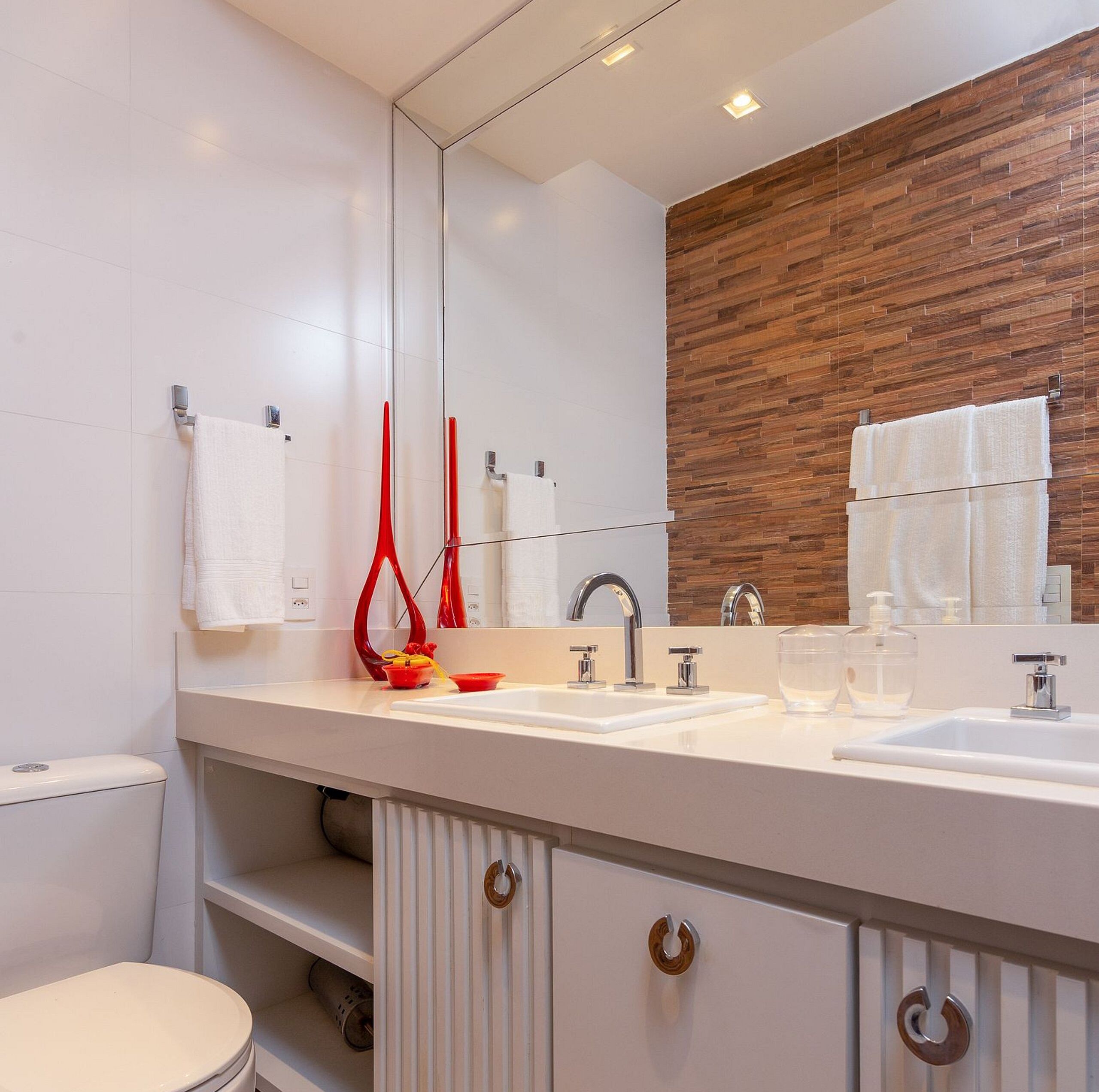 A modern bathroom with two sinks, a large mirror, and a wooden accent wall.