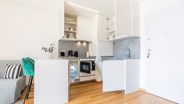 A compact kitchen with white cabinetry, a built-in oven, and a coffee machine. - Infante Studio w/ Parking by LovelyStay (Vila Nova de Gaia)