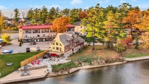 A lakeside property with a red-roofed building, a wooden cabin, and a small dock. - EXECUTIVE WATERFRONT LIVING AT ITS FINEST!!! WELCOME to this immaculate home! (Wasaga Beach)