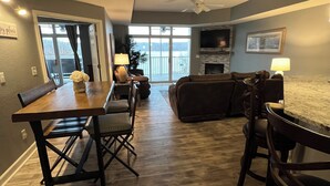 A spacious living area with a dining table, chairs, a sofa, and a TV. -  2110 Towers Beautiful Condo! Quiet! Elevators, indoor/outdoor pools. Free Wifi (Osage Beach)