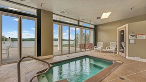 A pool area with a clear view of the outdoors, a pool with a safety ladder, and two chairs by the poolside. -  2110 Towers Beautiful Condo! Quiet! Elevators, indoor/outdoor pools. Free Wifi (Osage Beach)