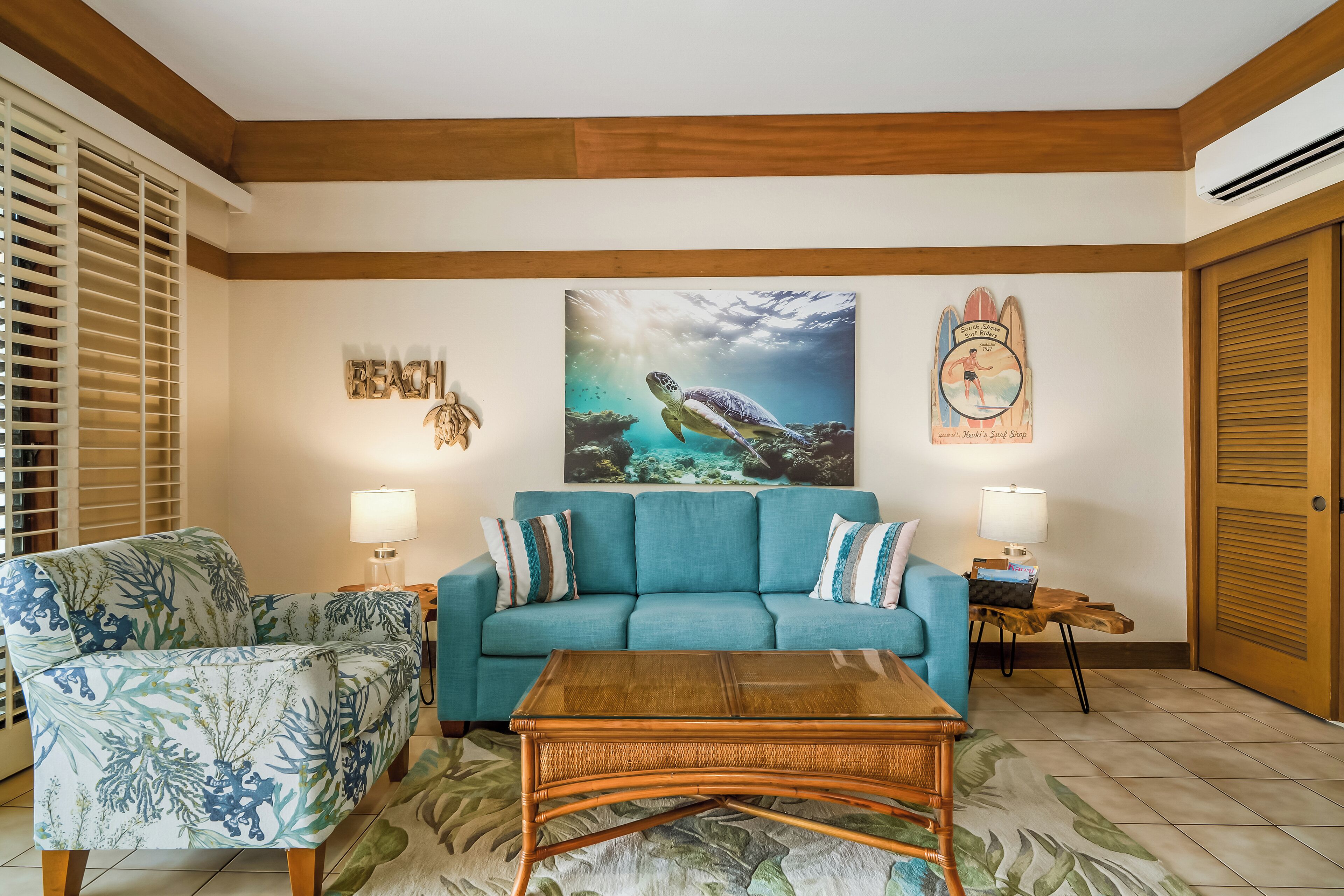A living room with a blue sofa, a patterned armchair, and a wooden coffee table.