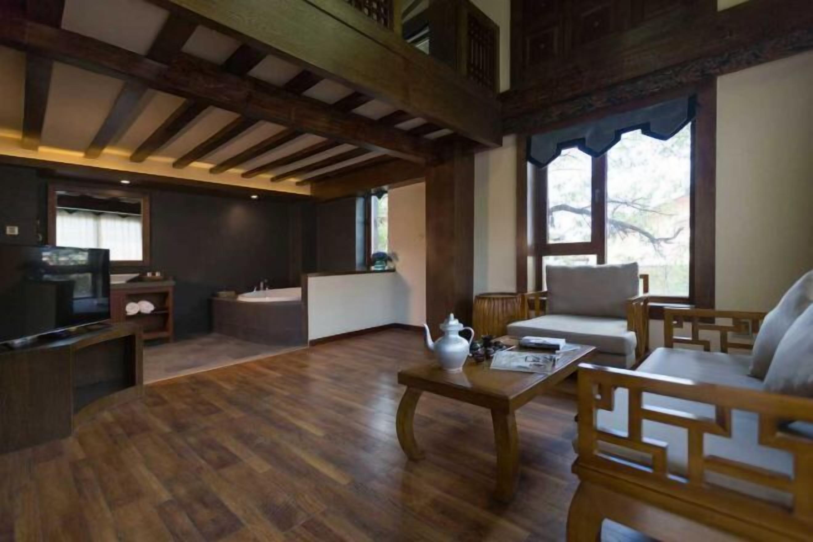 A traditional interior with wooden furniture, a television, and a window with a view.