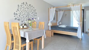 Une chambre à coucher avec un lit à baldaquin, une table à manger avec des chaises et une fresque murale.