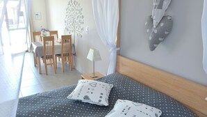 Une chambre à coucher bien rangée, avec un lit, des oreillers, une table de chevet et une lampe.