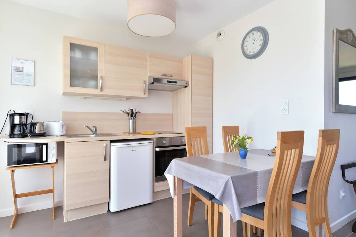 Una cucina moderna con mobili in legno, forno a incasso e un tavolo da pranzo con sedie.