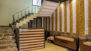 Un interior moderno con una escalera, un banco de madera y un revestimiento de pared con diseño.