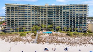 Un hotel grande con varios balcones, piscina y zona de playa.