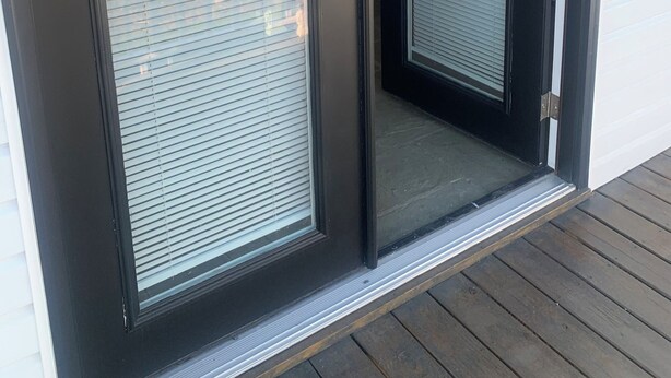 A sliding glass door with a metal handle and a small step leading to the door. - Welcome Traveling Nurses and Family’s to my3 bedroom 2 bathroom cozy home (Syracuse)