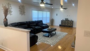 A modern living room with a sectional sofa, a coffee table, and a decorative vase. - Welcome Traveling Nurses and Family’s to my3 bedroom 2 bathroom cozy home (Syracuse)