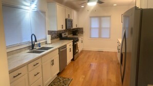 A kitchen with white cabinets, a microwave, a dishwasher, and a refrigerator. - Welcome Traveling Nurses and Family’s to my3 bedroom 2 bathroom cozy home (Syracuse)