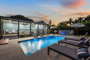 A swimming pool with lounge chairs and a covered seating area. - NEW Reno! Sleeps 14 + Heated Pool + 5 min to downtown! (West Palm Beach)