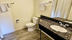 A bathroom with a toilet, sink, and towel rack. - Three Judges Motel (New Haven)