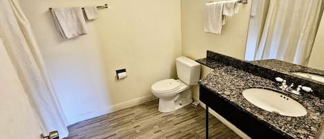 Une salle de bain équipée de toilettes, d’un lavabo et d’un porte-serviettes.