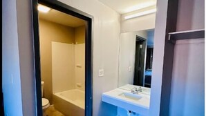 A bathroom with a bathtub, toilet, and sink. - Three Judges Motel (New Haven)