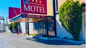 A motel with a large sign indicating it is a B JUDGES motel. There is a clear entrance with a sign for low clearance. - Three Judges Motel (New Haven)