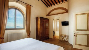 Une chambre à coucher avec un grand lit, une armoire, un téléviseur et une vue par la fenêtre.